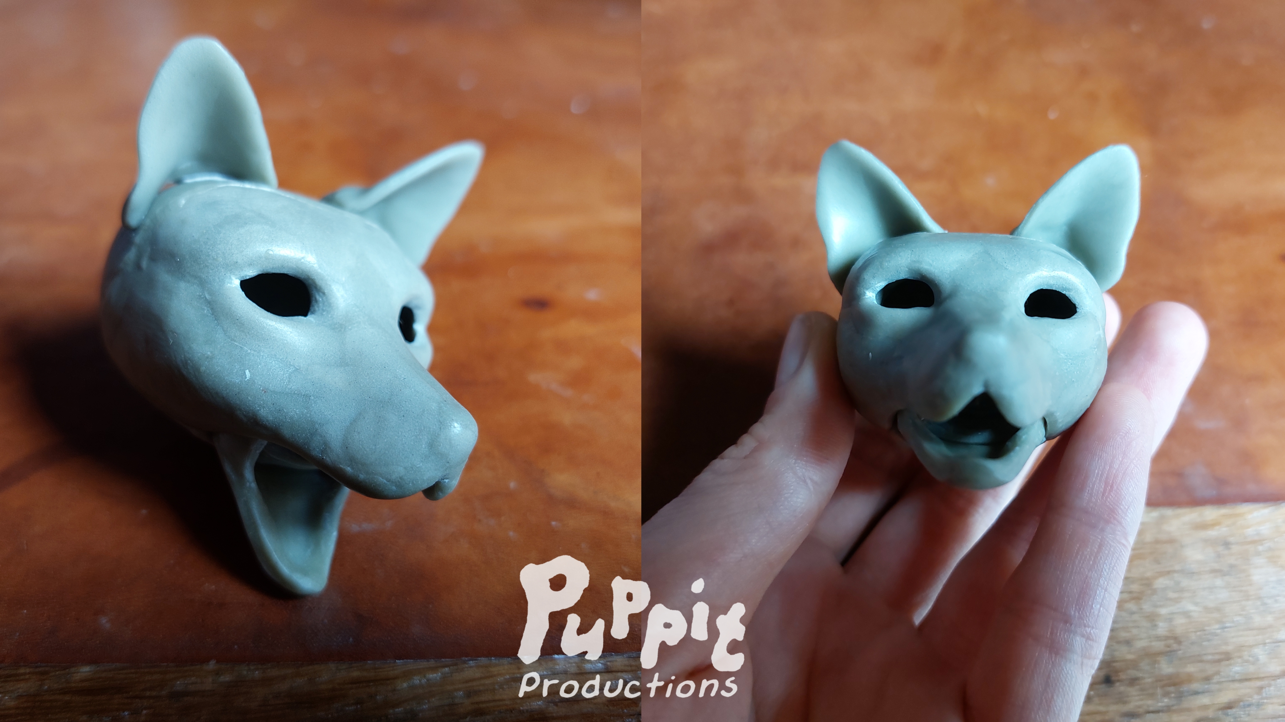 Two pictures side by side of a small red wolf doll head in grey clay, not fully detailed yet and without eyes. On the first picture the head is seen slightly from above at a roughly 30 degree angle with the mouth wide open. On the second picture the head is shown in a hand, positioned to be viewed directly from the front with the mouth halfway open.